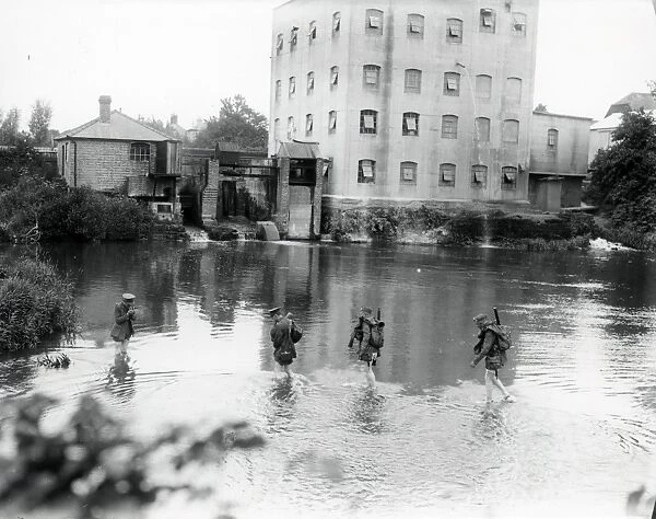 Two East Yorks soldiers and two officers wading through mill pond near Petworth