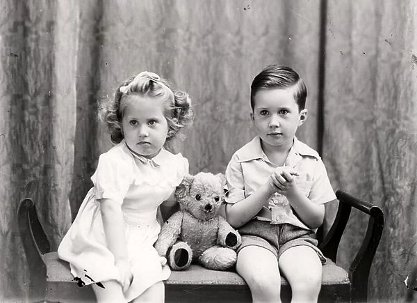 Girl and boy posing with a teddy bear