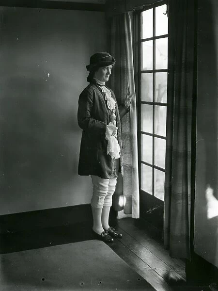 Lady in fancy dress gazing out of a window, February 1938