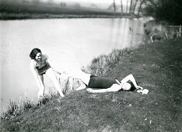Two young ladies playing on a river bank at Stopham, March 1938