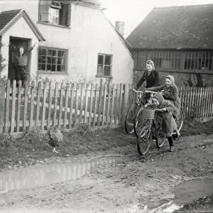 Three girls on bikes leaving home, December 1941