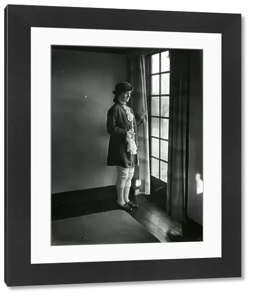Lady in fancy dress gazing out of a window, February 1938