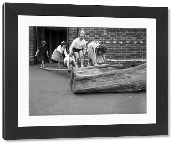 School children on a log at Lancastrian Infants School, Chichester, May 1956