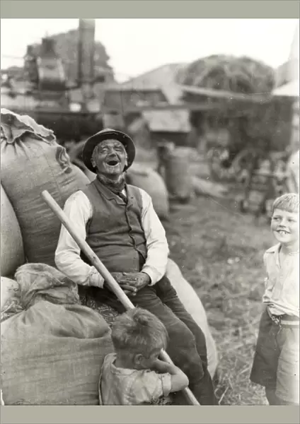Old character with young boys, threshing machinery in the background, 1932