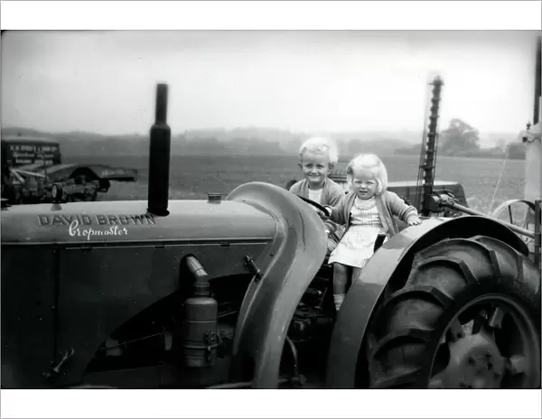 Two small children on a tractor, 1949