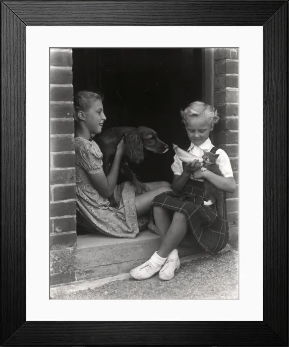 Framed Print : Two girls playing with a dog and a kitten, 1949 Framed Print : Two girls playing with a dog and a kitten, 1949