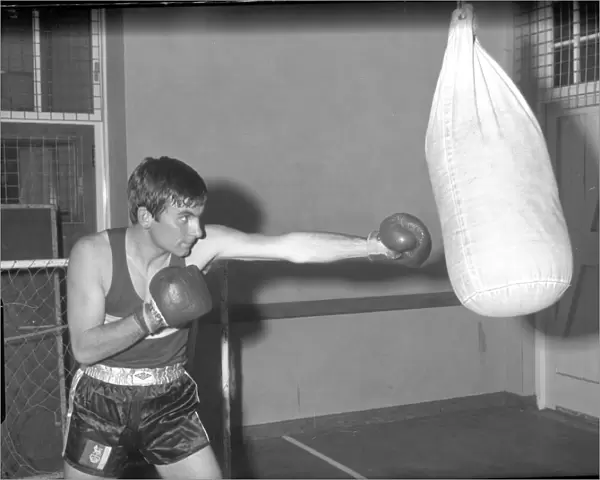 Boxer punching punch bag in training