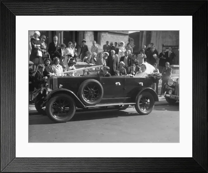 Framed Print : Wedding Day with Bride and Groom seated in open top motor car, 1960s