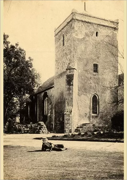Well-dressed man reclining on the lawn in front of the church at Beeding, 23 March 1893