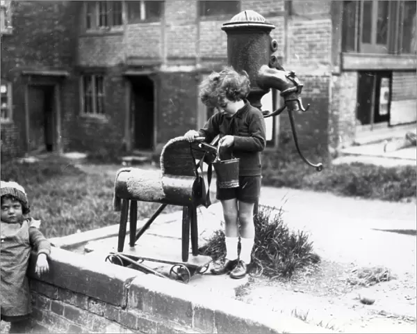 Young child pretending to water a wooden horse, August 1923