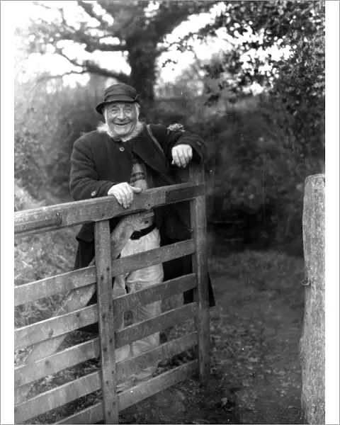 Gentleman standing behind farm gate at Upperton, Sussex