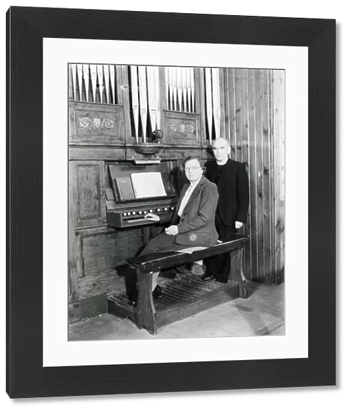 Organist and vicar seated at the organ