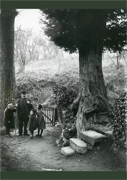 Old man and children walking in the country, December 1935