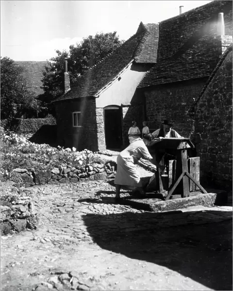 Two people using a well on a farm at Upperton, Sussex, August 1936
