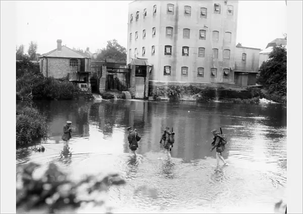 Two East Yorks soldiers and two officers wading through mill pond near Petworth