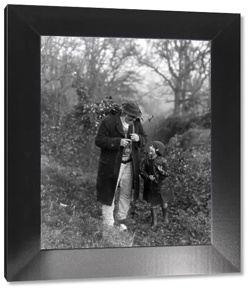 Grandfather and child gathering holly, December 1932