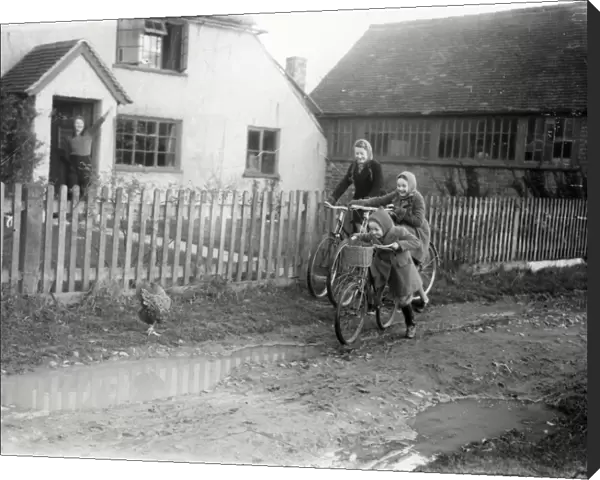 Three girls on bikes leaving home, December 1941