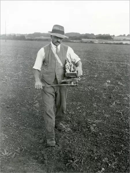 Farm worker fiddling trifolium [clover] seed, September 1933