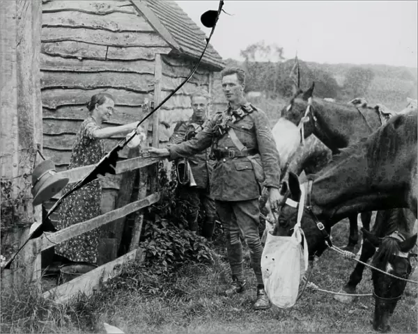Two Cavalry soldiers accepting a drink at a cottage, August 1936