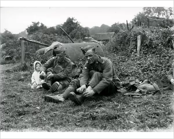 Lewis Gunners. East Yorks Regiment sitting talking to young child, August 1936