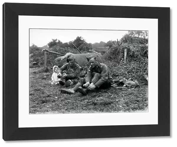 Lewis Gunners. East Yorks Regiment sitting talking to young child, August 1936