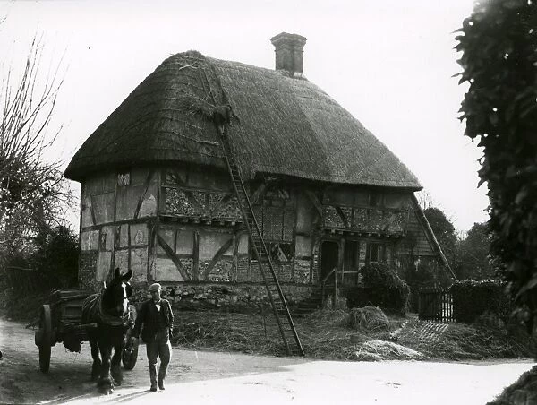 Bignor General Shop with thatcher at work, February 1938