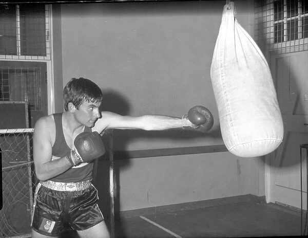 Boxer punching punch bag in training
