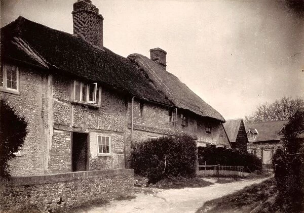 Compton, 1909. A group of cottages, one thatched, taken from road