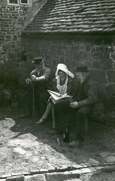 Three country folk discussing the news in a newspaper, Upperton, Sussex