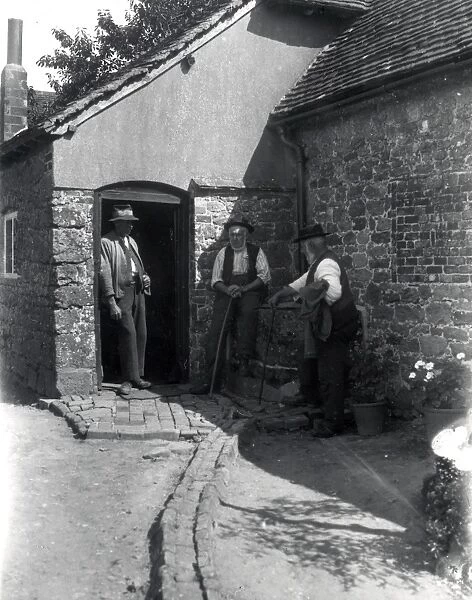 Three country gentlemen chatting in a farmyard at Upperton, Sussex. August 1936