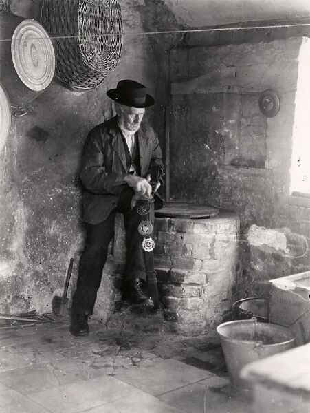 Elderly gentleman polishing horse brasses, September 1935