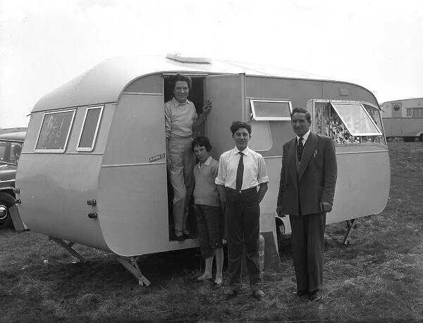 Family with caravan. Family pose next to their caravan, 25 April 1962