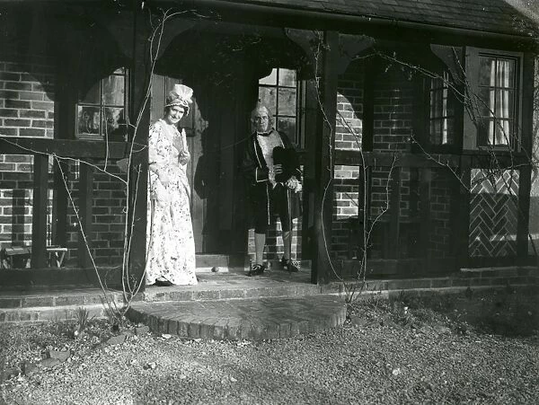 Lady and Gentleman in costume standing on a balcony, February 1938