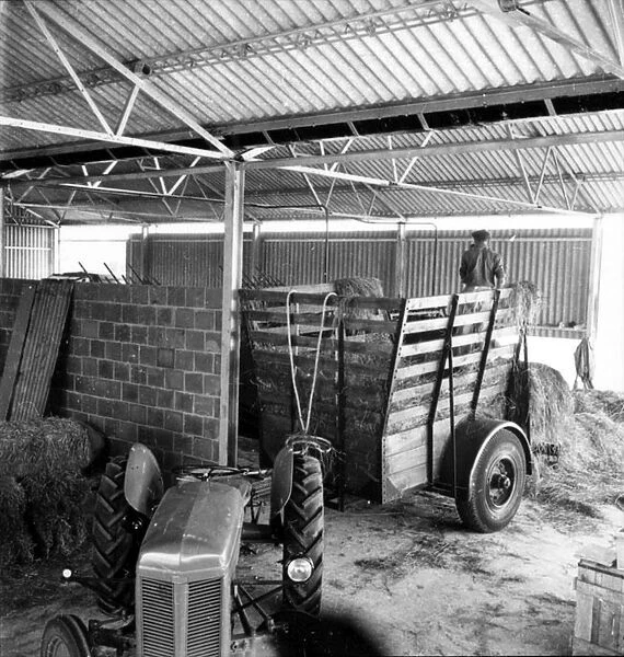 Old tractor and cart in a barn