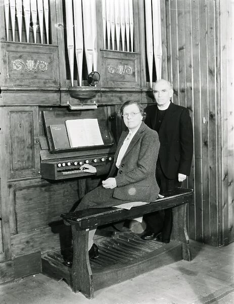 Organist and vicar seated at the organ