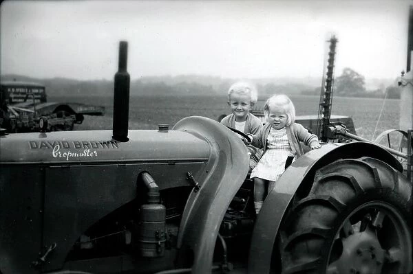 Two small children on a tractor, 1949