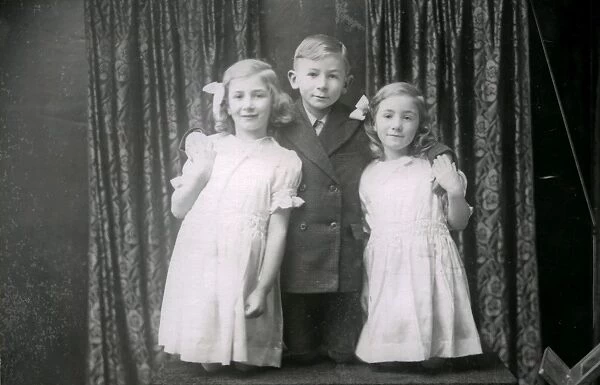 Studio portrait of two girls and a boy, December 1935