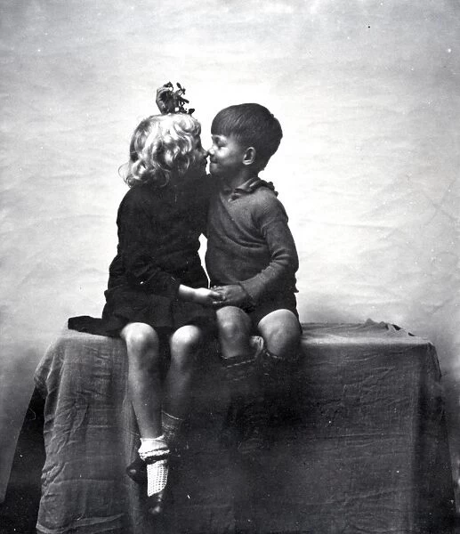 Young boy and girl kissing under mistletoe