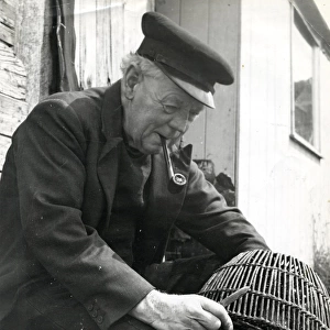 Fisherman mending a prawn pot, 1960s