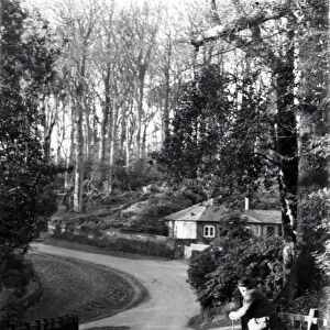 Gentleman leaning on stick in country lane, January 1935