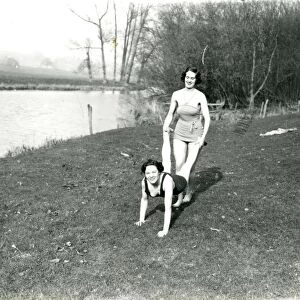 Two girls doing a wheelbarrow pose by the riverbank in Stopham, March 1938