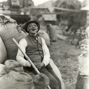 Old character with young boys, threshing machinery in the background, 1932