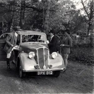 Three people getting into an old car, possibly a Standard, November 1936