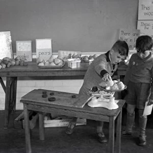 Two schoolboys weighing fruit at Lancastrian School, May 1956