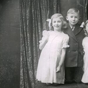 Studio portrait of two girls and a boy, December 1935