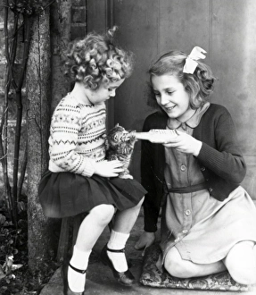 Bottle feeding a kitten - 1943