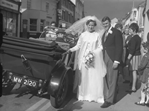 Wedding Prints: Bride and groom stood next to open top car