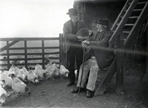 Bucket Prints: Two country folk feeding chickens in farm in Sussex