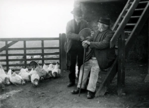 Barn Prints: Two elderly gentlemen feeding chickens at a farm in Sussex