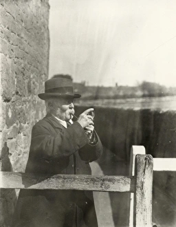 Gentleman lighting his pipe with a magnifying glass, March 1933 Gentleman lighting his pipe with a magnifying glass, March 1933